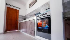 a kitchen with a tv in a wall at Wakesho Apartment A in Malindi