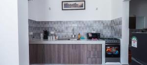 a kitchen with a sink and a stove at Wakesho Apartment A in Malindi +3 photos