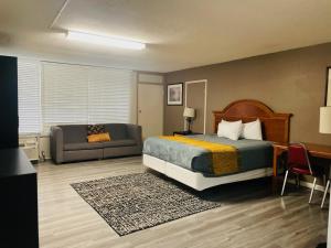 a hotel room with a bed and a couch at APM Inn & Suites in Martinsburg +30 photos