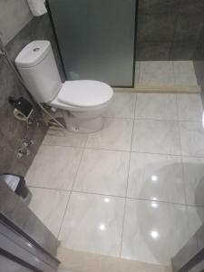 a bathroom with a toilet and a tiled floor at Capital Hotel in Downtown in Cairo