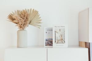a vase with a plant on a shelf with books at IUGAs RESIDENCE in Sighetu Marmaţiei +43 photos