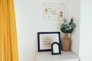 a shelf with a picture and a vase on it at IUGAs RESIDENCE in Sighetu Marmaţiei