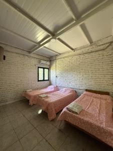 a room with two beds with pink sheets in it at Viñedos del Este in San Juan