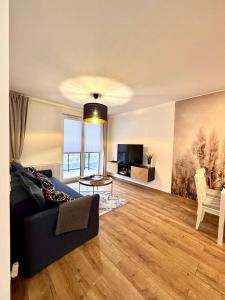 a living room with a couch and a television at Apartament Perła Łagowa in Łagów