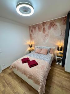 a bedroom with a bed with two towels on it at Apartament Perła Łagowa in Łagów +8 photos