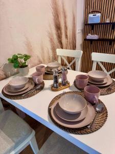 a table with plates and utensils on it at Apartament Perła Łagowa in Łagów