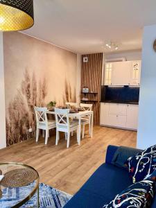 a living room with a dining table and a kitchen at Apartament Perła Łagowa in Łagów