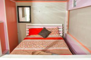 a small bedroom with a bed with red and orange pillows at Hidden Castle in Saint George