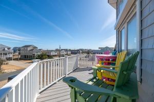 a deck with two colorful chairs on a house at Key to Paradise - Kitty Hawk MP 4, Pool, Hot Tub, Excellent Ocean View, Easy Beach Access in Kitty Hawk