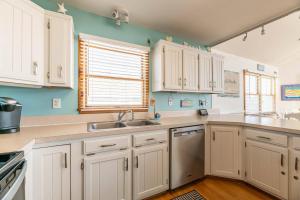 a kitchen with white cabinets and a sink at Key to Paradise - Kitty Hawk MP 4, Pool, Hot Tub, Excellent Ocean View, Easy Beach Access in Kitty Hawk +47 photos