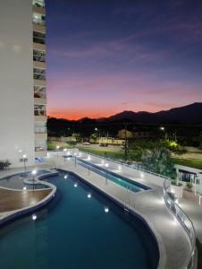 a view of a swimming pool at night at Lar dos Santoprete I in Bertioga