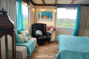 a bedroom with a chair and a bed and a chair istg at dream tiny house & luxury tent in Chania