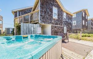 a hot tub on a deck in front of a house at The Tardis - Kitty Hawk MP 4.5, Ocean View, 275 Yds to Beach, Hot Tub, YR Flex Stays in Kitty Hawk