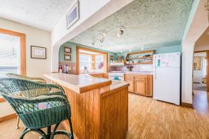 a kitchen with a white refrigerator and wooden cabinets at The Tardis - Kitty Hawk MP 4.5, Ocean View, 275 Yds to Beach, Hot Tub, YR Flex Stays in Kitty Hawk