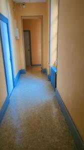 an empty hallway with a hallway leading to a door at Hôtel 2 Gares in Nevers