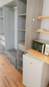 a kitchen with a closet with a microwave at Hôtel 2 Gares in Nevers