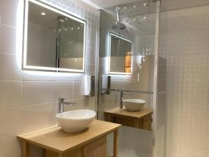 a bathroom with two sinks and a shower at Hôtel Angelic in Lourdes