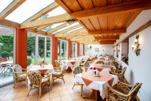a restaurant with tables and chairs and windows at Gräfliches Hotel Alte Post in Bad Birnbach