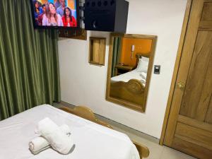 a room with a bed and a mirror and a tv at Hotel Bosque Chapinero in Bogotá +32 photos