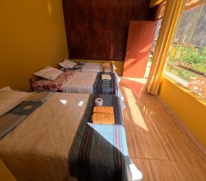 two beds in a room with a window at La Casa de Roy in Cosnihua +16 photos