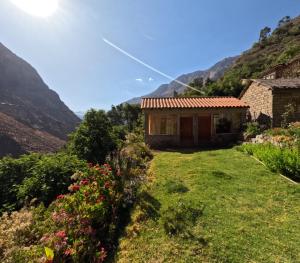 a house in a field with mountains in the background at La Casa de Roy in Cosnihua