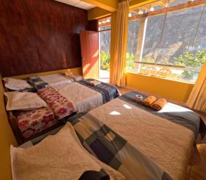 a bedroom with two beds and a large window at La Casa de Roy in Cosnihua