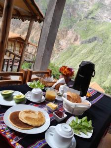 a table with a breakfast of pancakes and other food at La Casa de Roy in Cosnihua