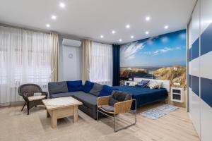 a living room with a blue couch and a table at Beachside Studio with Private Garden & Terrace 100m to the beach in Jūrmala