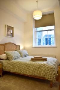 a bedroom with a bed with a window at Luxury Historic City-Centre Flat & Free Parking in Glasgow +27 photos