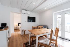 a kitchen and dining room with a wooden table and chairs at Casa da Chica Apartamento Castelo 1 Esq in Guimarães