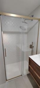 a shower with a glass door in a bathroom at Atico Queen Itimad in San Juan de Aznalfarache +28 photos