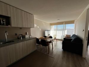 eine Küche und ein Wohnzimmer mit einem Tisch und einem Sofa in der Unterkunft Depto Parque Víctor lamas in Concepción