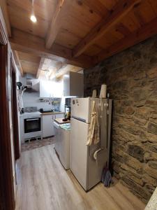 a kitchen with a refrigerator and a stone wall at Casa Nayala in Río Aller +92 photos