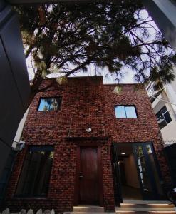 a red brick building with a brown door at Día y noche in Guadalajara