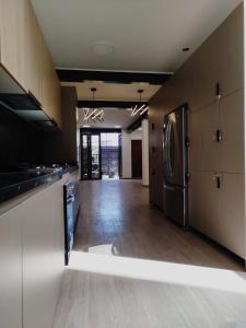 a kitchen with a stainless steel refrigerator and wooden cabinets at Día y noche in Guadalajara