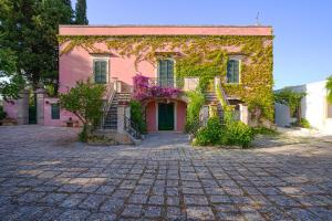 ein rosa Haus mit Efeu an der Seite in der Unterkunft Villa Morea-Relax in piscina in Putignano