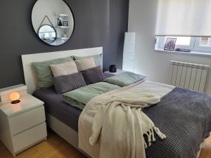a bedroom with a bed with a mirror on the wall at Apartman Riva Panoramska terasa & Privatna Garaža in Kraljevo