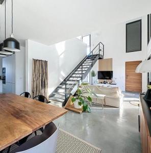 a living room with a staircase and a table at La parenthèse basque in BIQ