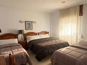 a hotel room with two beds and a window at Hotel Mesón el 21 in Almería +67 photos
