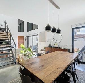 a dining room with a wooden table and some chairs at La parenthèse basque in BIQ