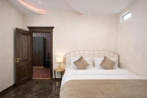 a bedroom with a bed with white sheets and pillows at Royal Renaissance Boutique by IGIT in Yerevan