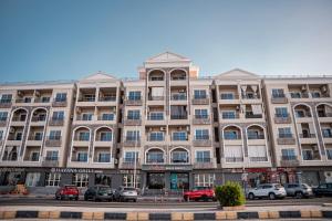 a large building with cars parked in a parking lot at Juliana Beach Hurghada in Hurghada