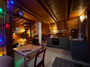 a kitchen with a table and a clock on the wall at Twin Forest, riverside cabin in Brod na Kupi