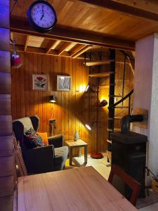 a room with a couch and a clock on the wall at Twin Forest, riverside cabin in Brod na Kupi
