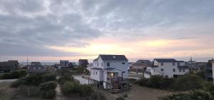 a house in the middle of a residential neighborhood at Carolina Cottage - Kitty Hawk, Oceanside, Walk to Beach, Pool, Hot Tub, Pool Table in Kitty Hawk