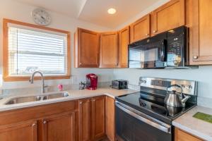 a kitchen with a sink and a stove top oven at Carolina Cottage - Kitty Hawk, Oceanside, Walk to Beach, Pool, Hot Tub, Pool Table in Kitty Hawk +53 photos