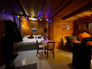 a bedroom with a bed and a table and chairs at Twin Forest, riverside cabin in Brod na Kupi
