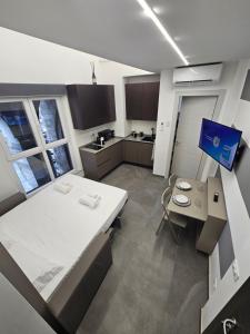 a kitchen with a large white bed and a table at Suite degli Archi - Luxury Suites fronte Acquario Porto Antico in Genoa