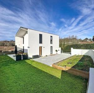a large white house with a grass yard at La parenthèse basque in BIQ