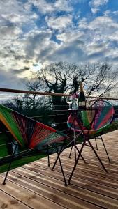 a table and chairs on a deck with a bottle of wine at Chambre dans demeure de caractère in Missy-sur-Aisne